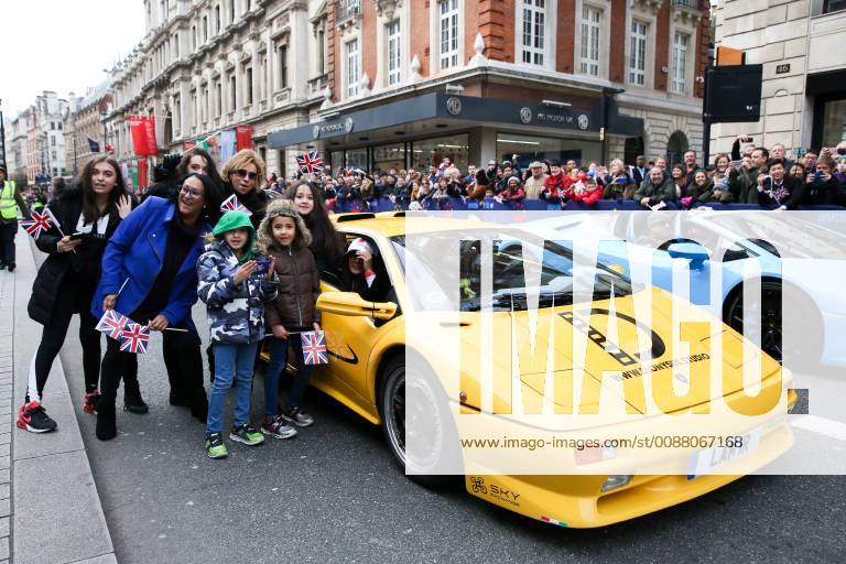 London, United Kingdom - People seen standing next to a Lamborghini during the parade..Over half a million spectators lined up the 2.2 mile route from Piccadilly Circus to Parliament Square as more than 8,000 performers from 26 countries participated in the 33rd Londons New Year s Day Parade. London United Kingdom - ZUMAs197 20190101_zaa_s197_055