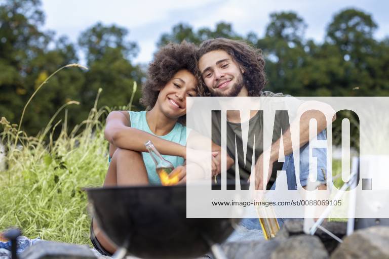 Happy couple having a barbecue in the nature model released Symbolfoto FMKF05243
