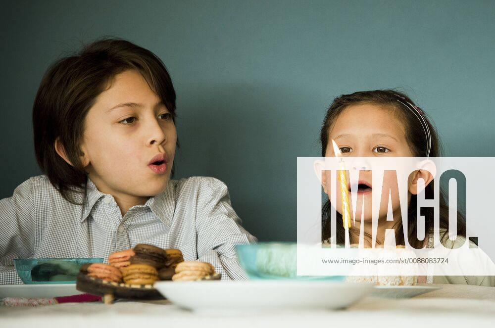 Girl blowing out candle on birthday cake