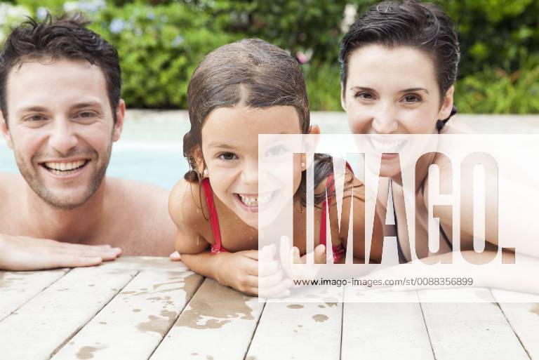 Family relaxing together in pool, portrait