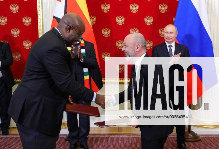 Zimbabwe s Minister of Mines and Mining Development Winston Chitando (L front) and the General Manager of GDI (Great Dyke Investments) Igor Khiger (Igor Higer) (R front) shake hands at a signing ceremony as Zimbabwe s President Emmerson Mnangagwa (L back) and Russia s President Vladimir Putin (R back) look on at the Moscow Kremlin. Mikhail Klimentyev Russian Presidential Press and Information Office TASS TS09DD6B