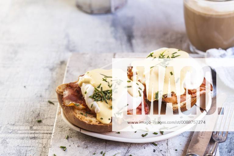 Traditional egg benedict with slices of bacon on toast, poached egg and hollandaise SBDF03827