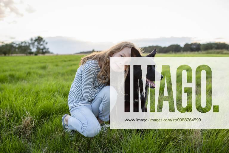 Girl with a dog sitting on a field model released Symbolfoto property released OJF00273