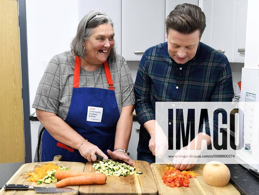 . 24 01 2019. London, United Kingdom. Tesco Community Cookery School with Jamie Oliver. Tesco Community Cookery School with Jamie Oliver will train 1,000 community cooks this year to stop good food going to waste. Pictured Jamie Oliver with Doris Hester, cook at Goodinge Community Centre, central London. xAndrewxParsonsx xi-Imagesx IIM-19184-0005