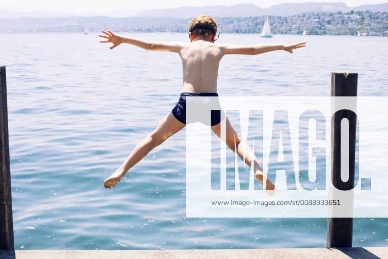 Boy jumping into lake