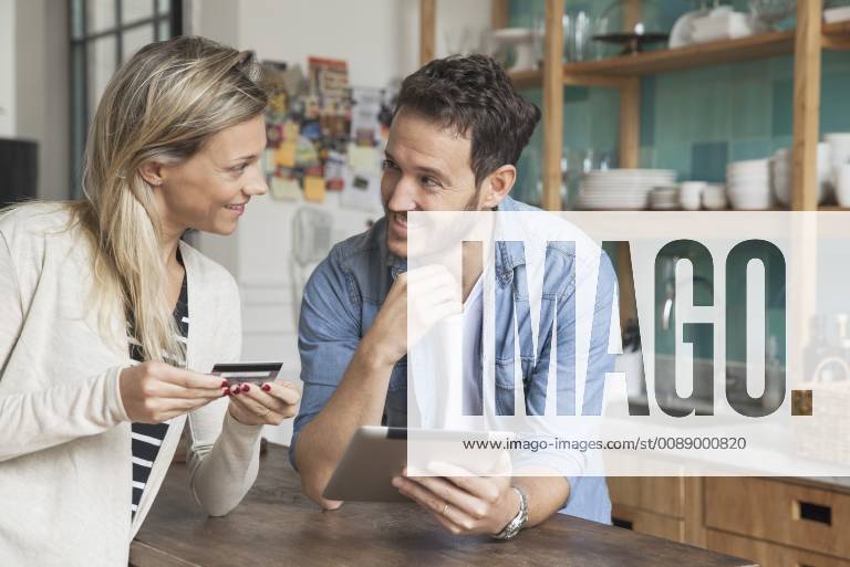 Couple using digital tablet to shop online at home