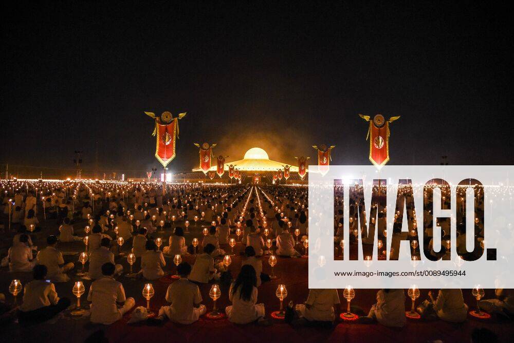 Thailand: Makha Bucha Day Ceremony Buddhist monks hold candles as they walking around the Buddha Statue during a ceremony to commemorate Makha Bucha Day at Wat Phra Dhammakaya Temple in Pathum Thani province during Thai people celebrate the buddhist festival of clockwise circumambulation and Makha Bucha lantern lighting ceremony at Dhammakaya Temple on Makha Bucha Day during the third lunar moon, where around 1250 monks gathered to be ordained by the Buddha and hundreds thousands of devotees holding lanterns. Pathum Thani Thailand VichanxPoti