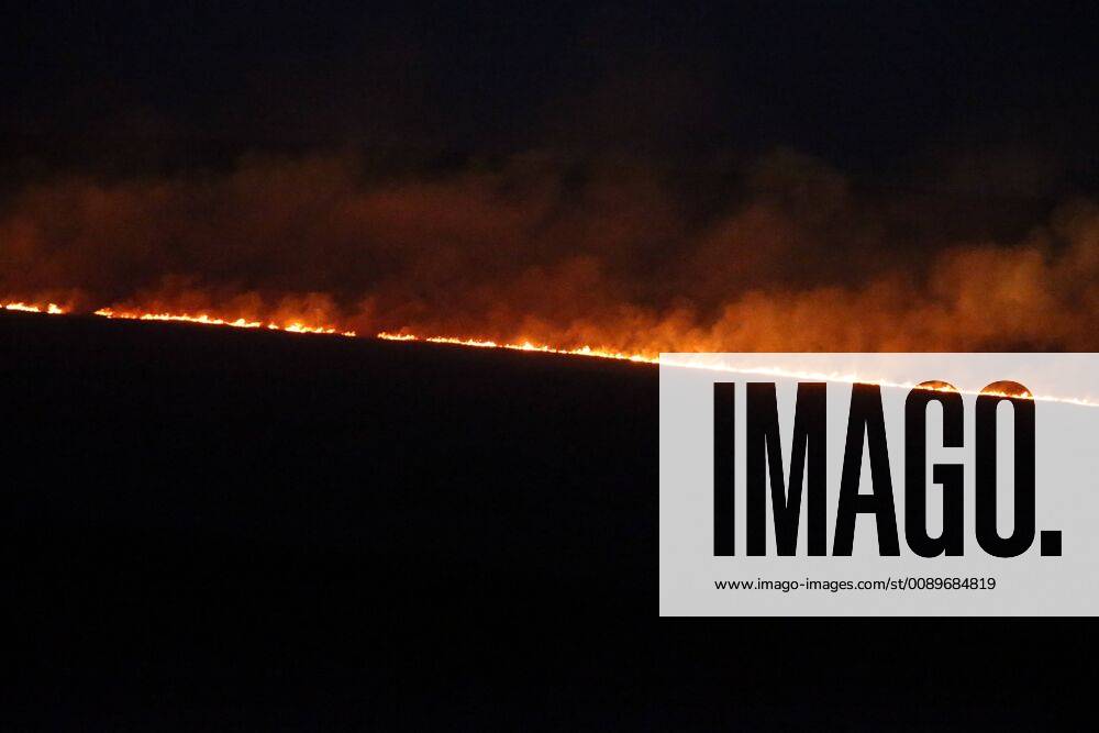 Marsden, Yorkshire, U.K. - Flames glows on the horizon before sunrise as a huge wildfire on Saddleworth moor this morning near the town of Marsden in Yorkshire. Firefighters have contained a blaze that erupted on moorland in West Yorkshire in northern England, one of the three wildfires that broke out across the United Kingdom as temperatures hit record seasonal highs. Marsden UK - ZUMAl94_ 20190227_zaf_l94_001