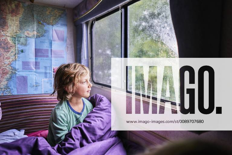Boy in pyjama looking out of window of a camper model released Symbolfoto property released SSCF00162