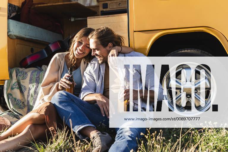 Affectionate couple on a road trip, taking a break, drinking soft drinks model released Symbolfoto UUF16179