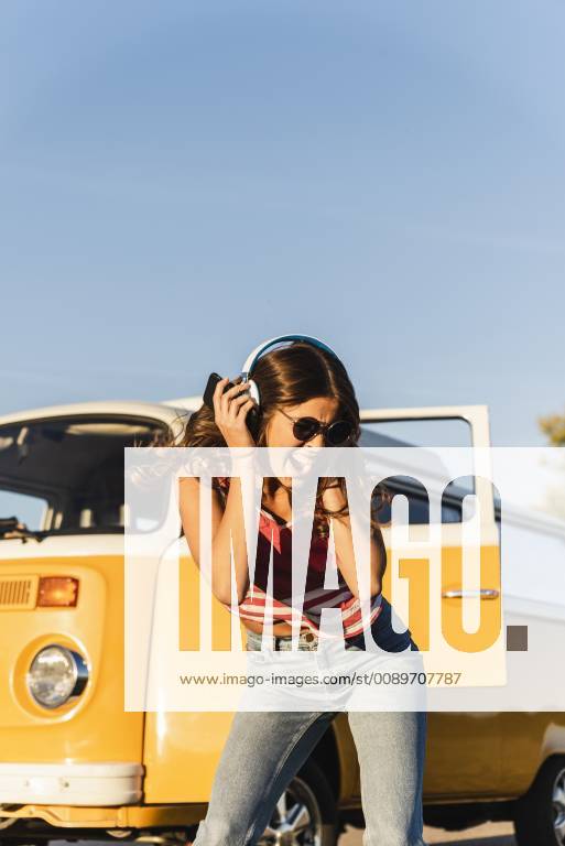 Pretty woman on a road trip with her camper, dancing, listening music model released Symbolfoto UUF16236