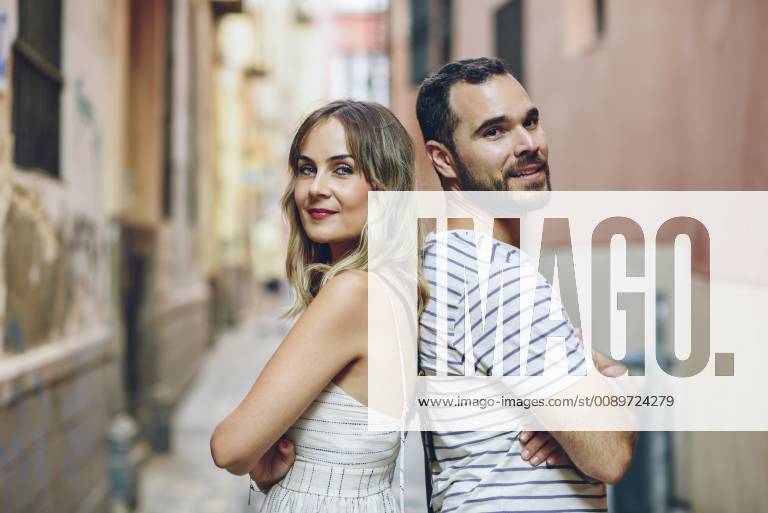 Spain, Andalusia, Malaga, portrait of a tourist couple standing back to back in the city model released Symbolfoto JSMF00611