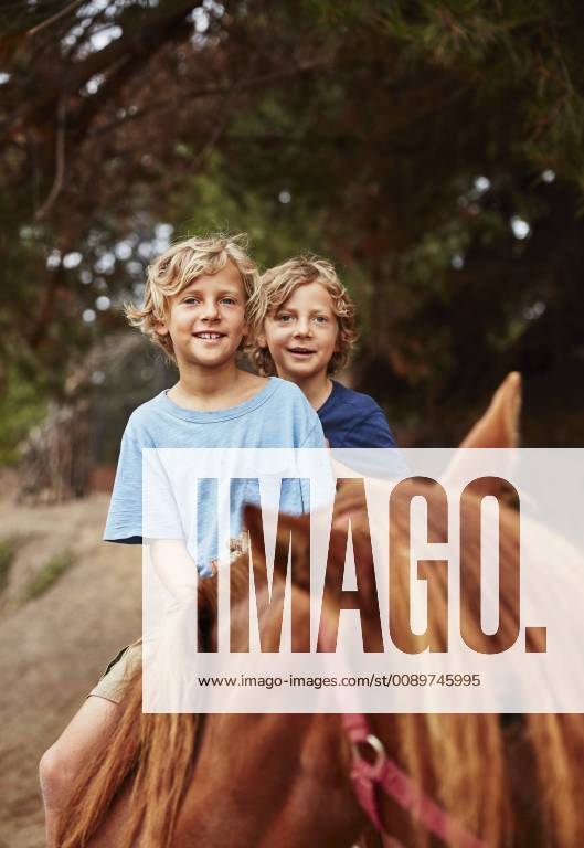 Portrait of two happy boys on horse in a forest model released Symbolfoto SSCF00092