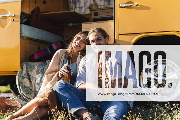 Affectionate couple on a road trip, taking a break, drinking soft drinks model released Symbolfoto UUF16177