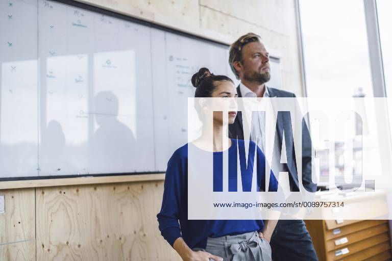 Mature man and his assistent, standing in office in front of white board model released Symbolfoto property released RIBF00844