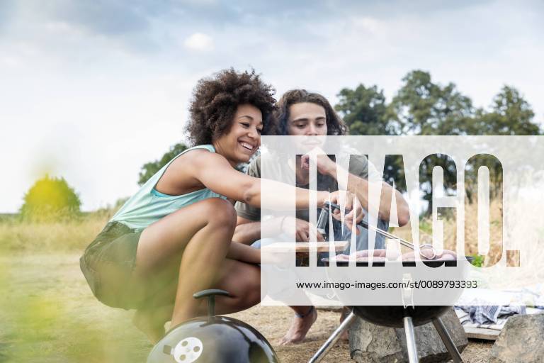 Happy couple having a barbecue in the nature model released Symbolfoto FMKF05279