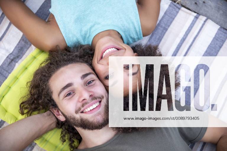 Portrait of happy couple lying on a blanket outdoors model released Symbolfoto FMKF05285
