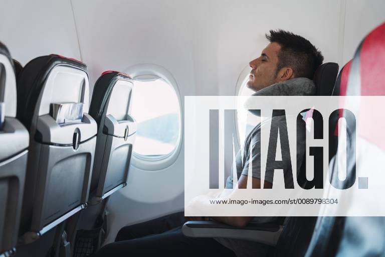 Man sleeping with neck pillow in airplane model released Symbolfoto KKAF02468