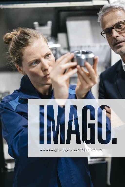 Manager and skilled worker in high tech enterprise, checking machine parts model released Symbolfoto property released KNSF04936