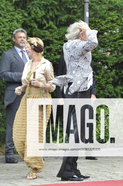 Nach über 40 Jahren Ehe Thea und Thomas Gottschalk haben sich getrennt. Archivfoto: Bayreuther Windspiele-haelt die Frisur? Moderator Thomas GOTTSCHALK haelt seine Frisur mit den Haenden zusammen-li:Ehefrau Thea. Eroeffnung der Bayreuther Richard Wagner Festspiele. Roter Teppich am 25.07.2015. Gruener Huegel, Festspielhaus.Bayreuth.