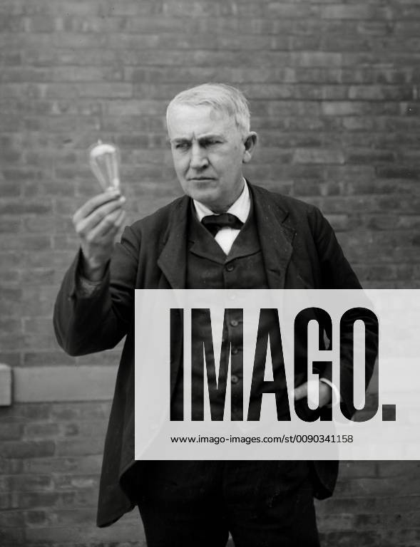 Inventor and physicist Thomas Alva Edison looking at his light bulb invention, circa (1911) File Reference 1003_825THA Hollywood CA USA