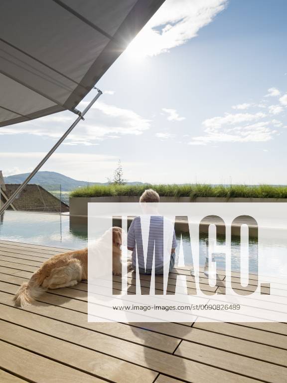 Senior woman sitting with dog at the poolside model released Symbolfoto property released LAF02204