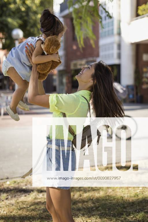 Happy mother lifting up daughter outdoors in the city model released Symbolfoto MAUF02397