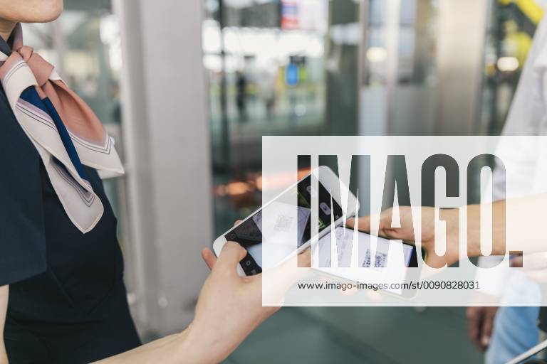Airline employee scanning QR codes of passengers with smartphone at the airport model released Symbolfoto property released MFF04730