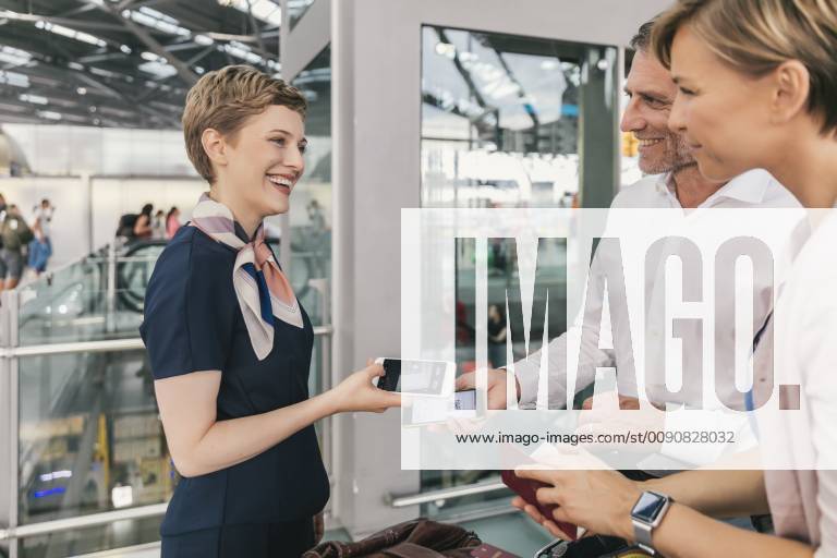 Airline employee scanning QR codes of passengers with smartphone at the airport model released Symbolfoto property released MFF04731