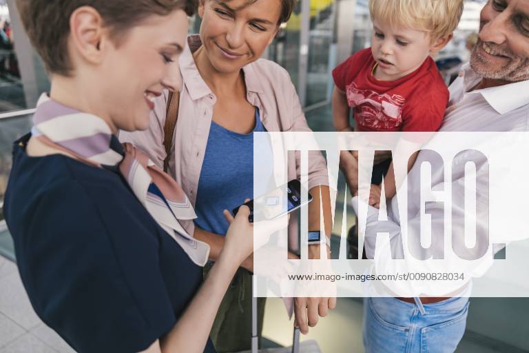Airline employee scanning QR codes of passengers with smartwatch at the airport model released Symbolfoto property released MFF04733