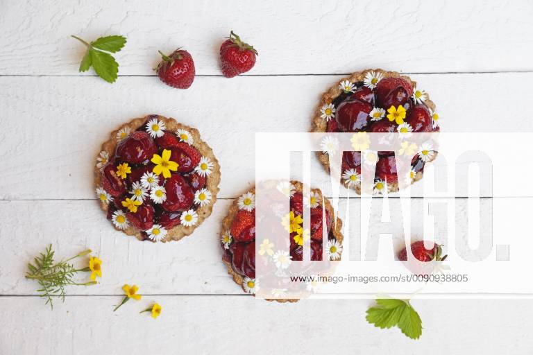 Homemade strawberry heart tartlets with daisy flowers and golden marigold, edible flowers, white wood GWF06023