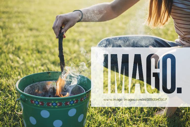 Woman barbecueing on a meadow, partial view model released Symbolfoto JSCF00124
