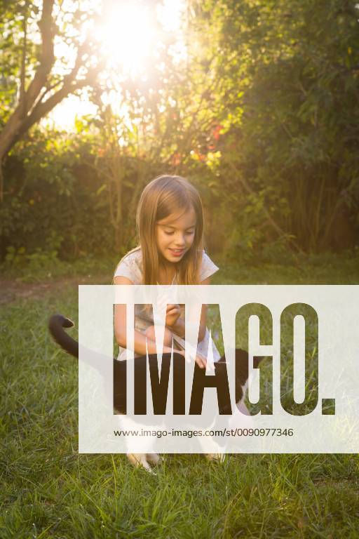 Smiling little girl stroking cat in the garden model released Symbolfoto property released LVF07611