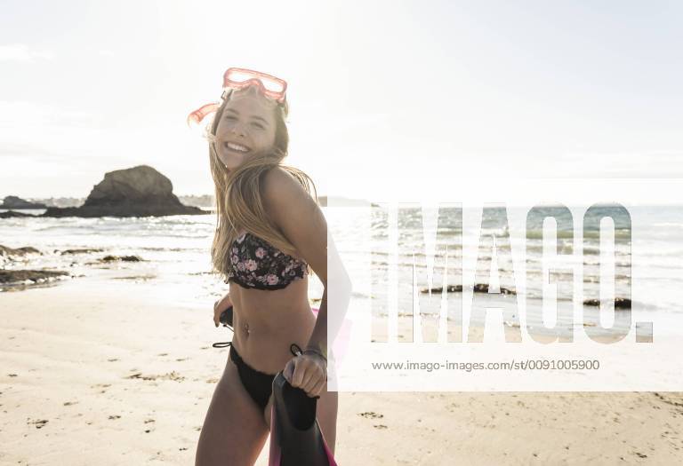 Happy young woman with snorkelling equipment, running on the beach model released Symbolfoto UUF16500