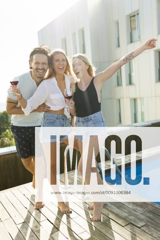 Friends having fun at a rooftop pool, drinking red wine model released Symbolfoto property released VABF02112
