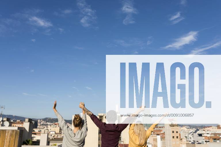 Friends having fun on an urban rooftop terrace, raising arms model released Symbolfoto VABF02202