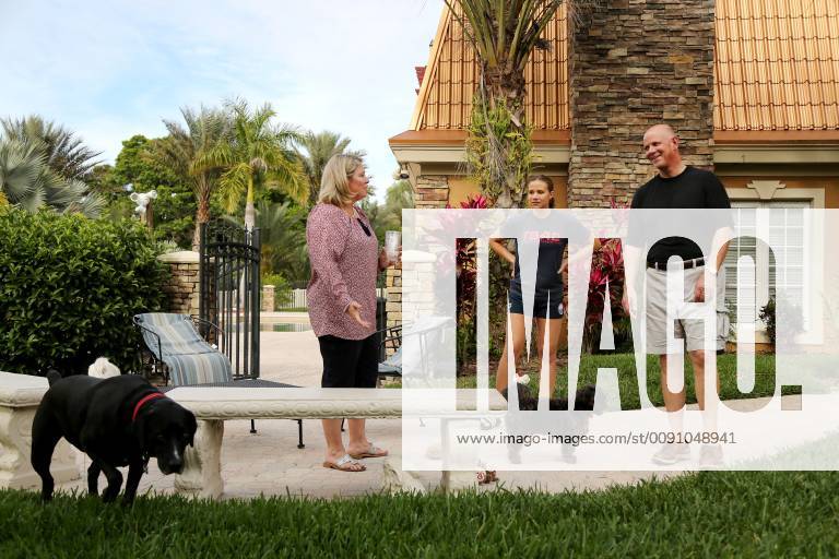 Palm Harbor, Florida, U.S. - DOUGLAS R. CLIFFORD Times.Pasco Circuit judge Lauralee Westine, left, Lauren Gaultieri, 13, and Pinellas County Sheriff Bob Gualtieri visit while giving their dogs McDuff and Graham a bathroom break outside their home in Palm Harbor (3 31 19) Palm Harbor U.S. - ZUMAs70_ 20190331_zan_s70_037