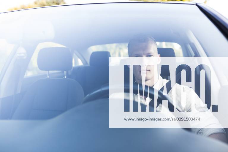 Young man driving car model released Symbolfoto ABZF02247