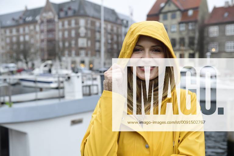 Denmark, Copenhagen, portrait of happy woman at city harbour in rainy weather model released Symbolfoto ECPF00623