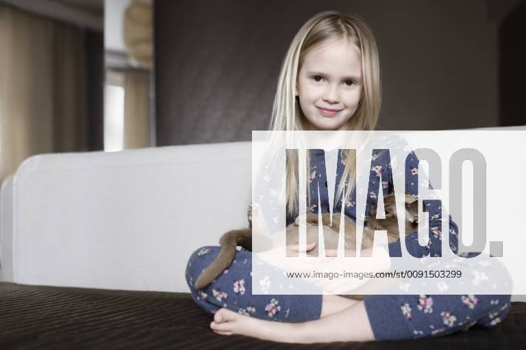 Portrait of smiling little girl wearing pyjama with floral design holding cat in her arms model released Symbolfoto property released EYAF00076