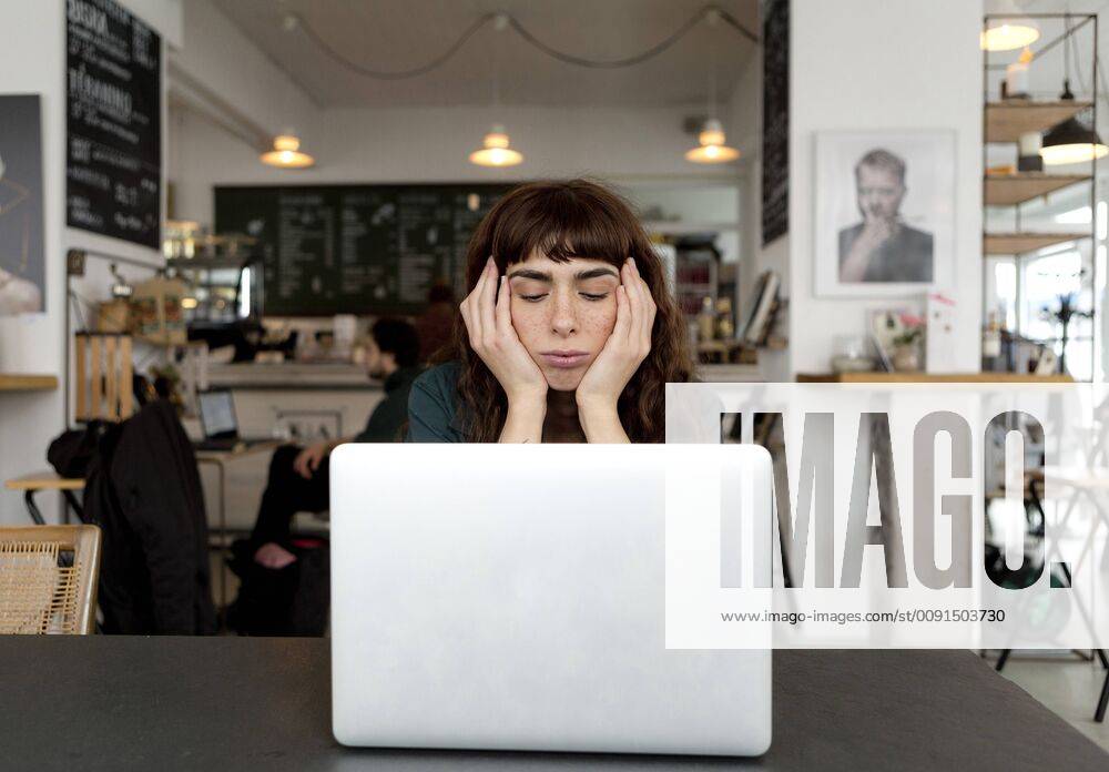 Frustrated young woman using laptop in a cafe model released Symbolfoto property released FLLF00066
