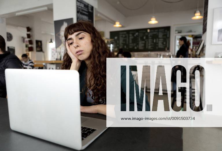 Frustrated young woman using laptop in a cafe model released Symbolfoto property released FLLF00067