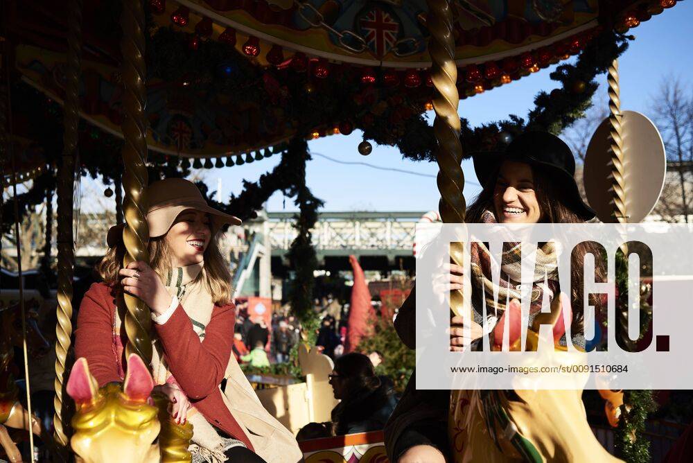 Two happy women having fun on a carousel model released Symbolfoto IGGF01142