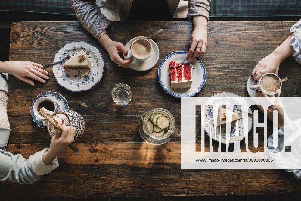 Top view of friends sitting at wooden table in a cafe model released Symbolfoto AHSF00140