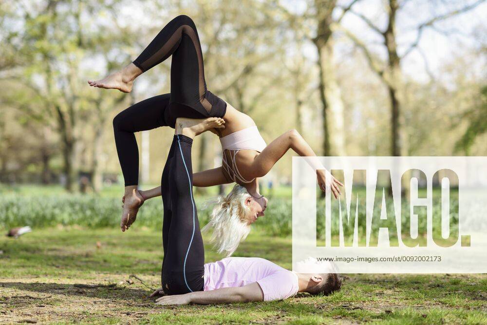 Young couple doing yoga acrobatics in an urban park model released Symbolfoto JSMF01080