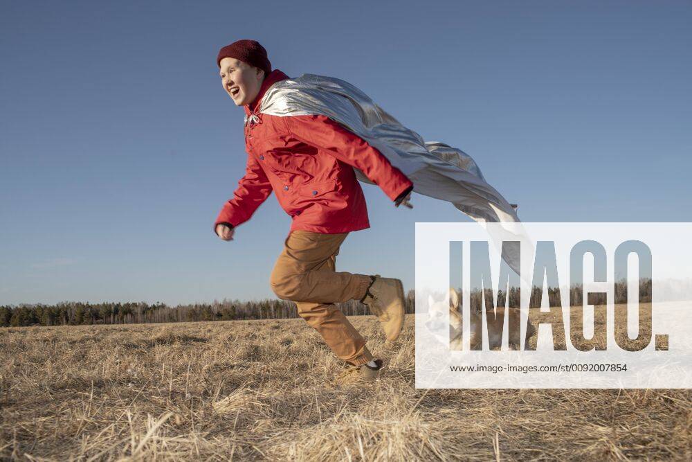 Boy dressed up as superhero running with dog in steppe landscape model released Symbolfoto property released VPIF01235
