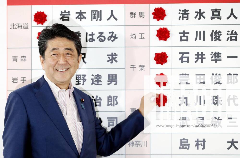 Japan upper house election Japanese Prime Minister and Liberal Democratic Party leader Shinzo Abe attaches a rosette to the name of an LDP candidate assured of victory in the House of Councillors election on July 21, 2019, at the party s election operations center in Tokyo.