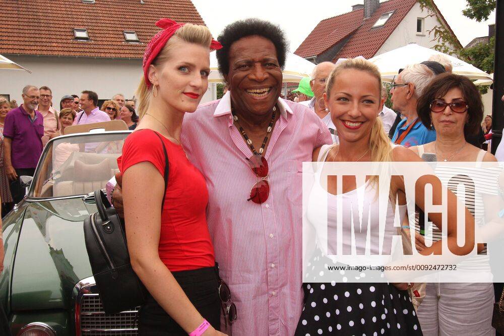 Tradtionelles Festival Golden Oldies in Wettenberg bei Giessen, Hessen, Deutschland: Sänger Roberto Blanco gut gelaunt mit zwei jungen Damen im Arm vor einem Mercedes Oldtimer.