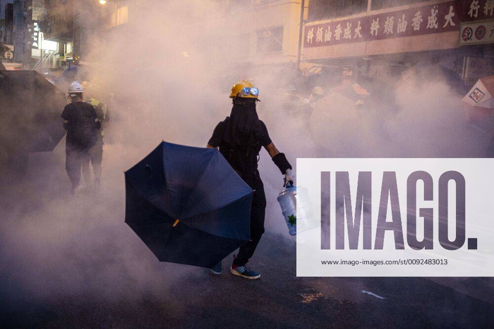 A Protester is seen holding up an umbrella while he walks through tear gas during a protest in Hong Kong on July 28, 2019, Protester take to the streets of Hong Kong in Protest of Police violence and the extradition bill -- Protester clashes with police in the evening with police firing tear gas and rubber bullets to disperse protester Hong Kong China - ZUMAn230 20190728_zaa_n230_556