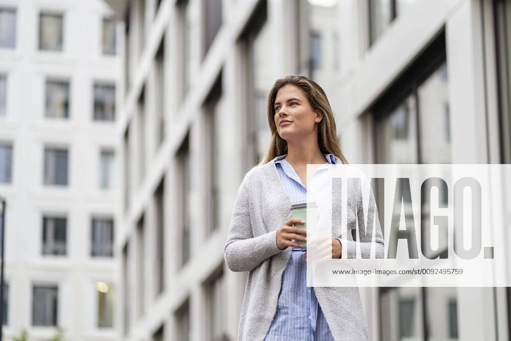 Young businesswoman with coffee to go cup, office building in the background model released Symbolfoto DIGF07086